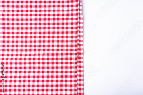 Background the tablecloth checkered red and white fabric cotton place on a white table with copy space.
