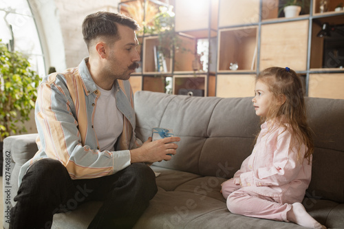 Happy father and little cute daughter at home. Family time, togehterness, parenting and happy childhood concept. Weekend with sincere emotions. photo