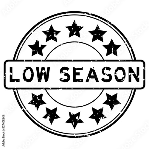 Grunge black low season word with star icon round rubber seal stamp on white background