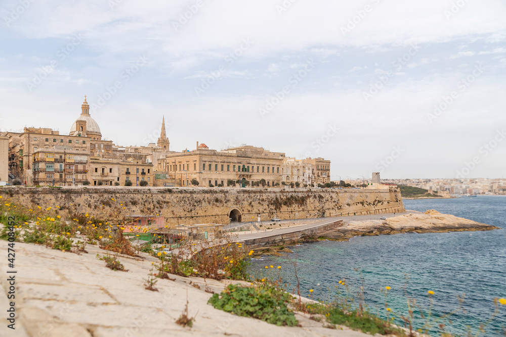 Panorama of Valletta, capital of Malta. Ancient buildings with old fashioned balconies and urban roads. Mediterranean sea embankment.