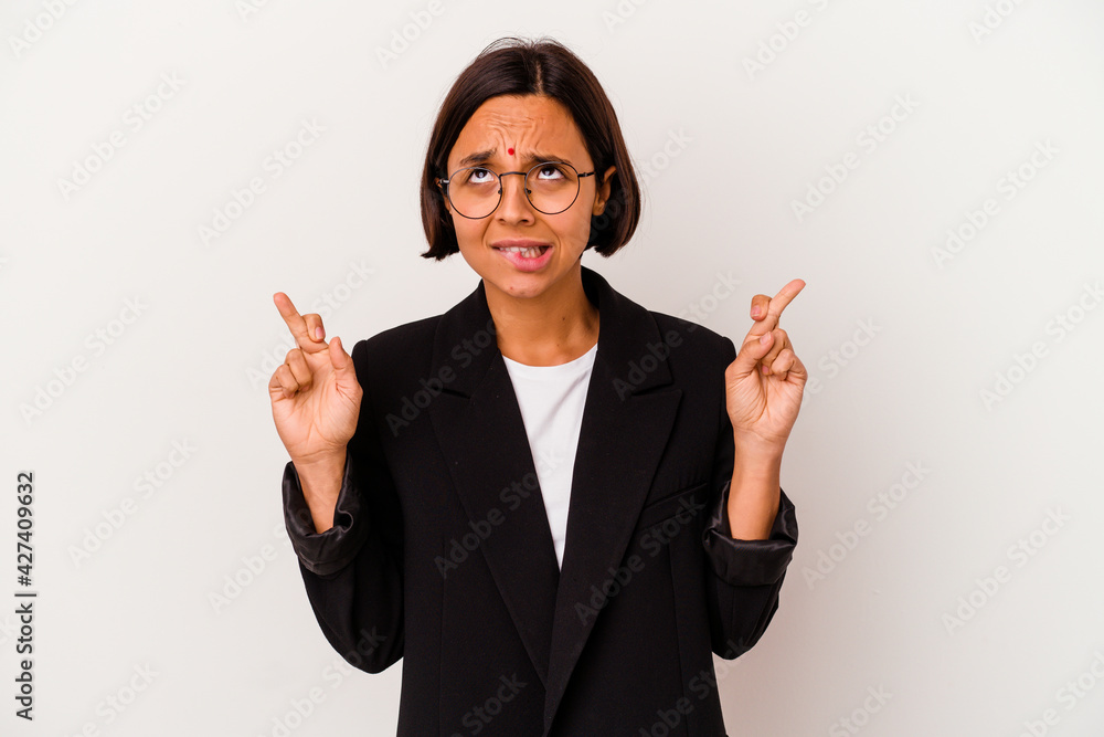 Young business Indian woman isolated on white background crossing fingers for having luck Young business Indian woman isolated on white background crossing fingers for having luck
