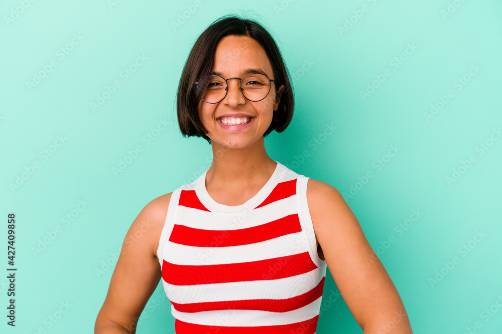 Young mixed race woman isolated on blue background confident keeping hands on hips. Young mixed race woman isolated on blue background confident keeping hands on hips.