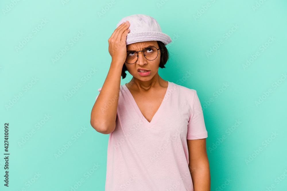 Young mixed race woman isolated on blue background forgetting something, slapping forehead with palm and closing eyes. Young mixed race woman isolated on blue background forgetting something, slapping forehead with palm and closing eyes.