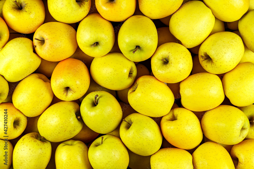 Background of many yellow apple pieces, overhead view, studio food photography.
