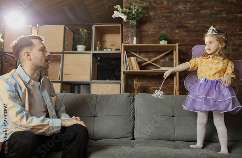 Happy father and little cute daughter at home. Family time, togehterness, parenting and happy childhood concept. Weekend with sincere emotions. photo