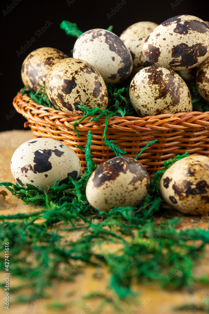 Top view of quail eggs in basket, selective focus, on rustic wooden table with green grass, black background, vertical Top view of quail eggs in basket, selective focus, on rustic wooden table with green grass, black background, vertical