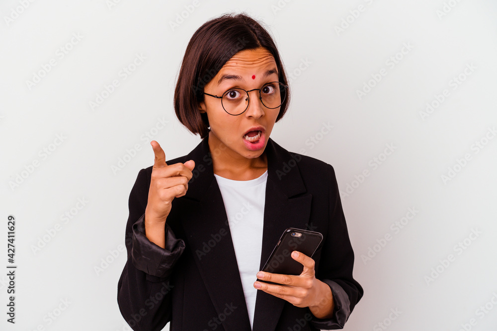 Young indian business woman holding a phone isolated having an idea, inspiration concept. Young indian business woman holding a phone isolated having an idea, inspiration concept.
