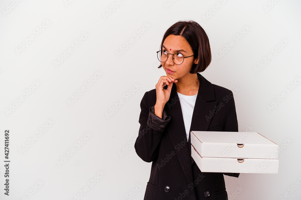 Young business indian woman holding pizzas isolated looking sideways with doubtful and skeptical expression. Young business indian woman holding pizzas isolated looking sideways with doubtful and skeptical expression.