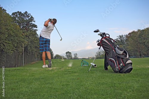 Young golfer impact exercise on green grass field
