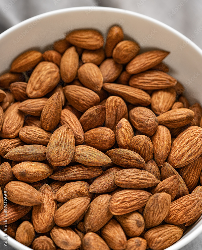 Fototapeta premium Almonds in bowl.Selective focus.Top view.Food backgound.