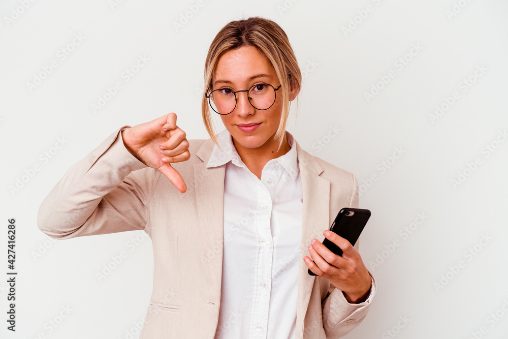 Young caucasian business woman holding mobile isolated on white background showing a dislike gesture, thumbs down. Disagreement concept.