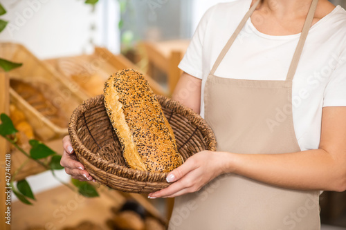 Female hands holding basket with loaf of bread
