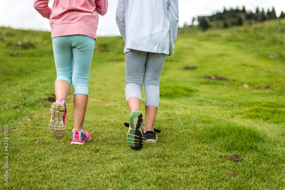 Children hiking in mountains or meadows with sport hiking shoes. Children hiking in mountains or meadows with sport hiking shoes.