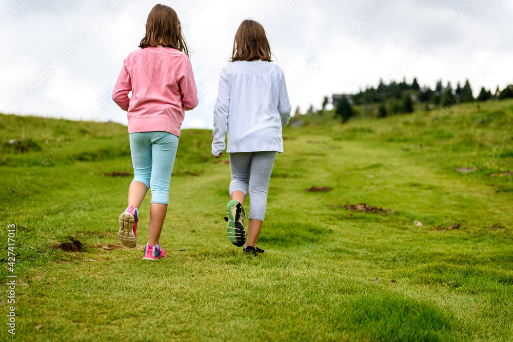 Children hiking in mountains or meadows with sport hiking shoes. Children hiking in mountains or meadows with sport hiking shoes.