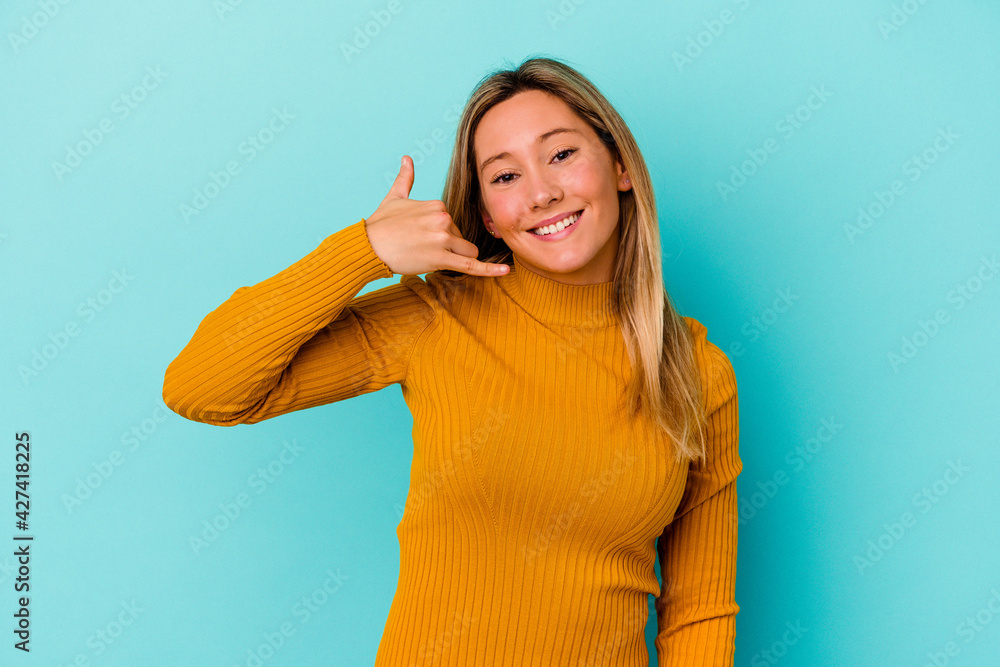 Young mixed race woman isolated on blue background showing a mobile phone call gesture with fingers. Young mixed race woman isolated on blue background showing a mobile phone call gesture with fingers.