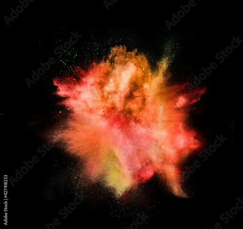 Explosion of colored  fluid and neoned powder on black studio background with copyspace