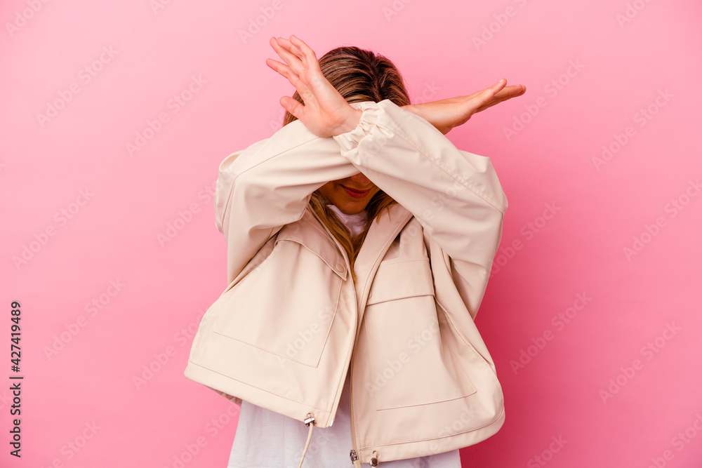 Young mixed race woman isolated on pink background keeping two arms crossed, denial concept. Young mixed race woman isolated on pink background keeping two arms crossed, denial concept.