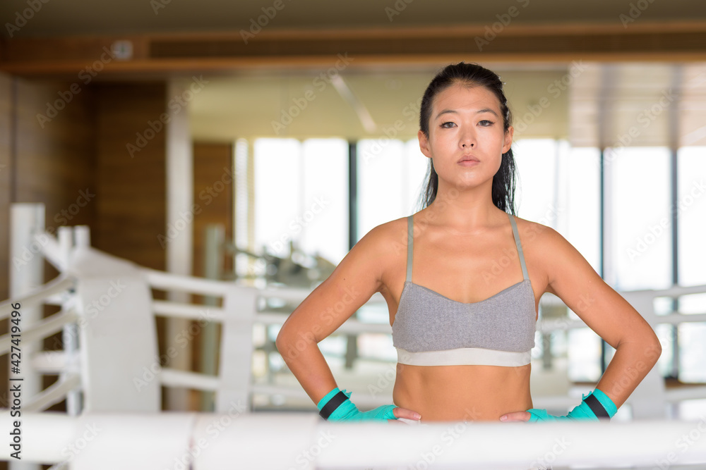 Portrait of beautiful Asian woman kick boxer ready for exercise at gym boxing ring Portrait of beautiful Asian woman kick boxer ready for exercise at gym boxing ring