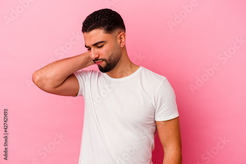 Young mixed race man isolated on pink background © Asier