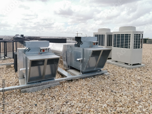 View of air ventilation ducts, extraction and insufflation, HVAC system, and exterior AC units on the building roof
