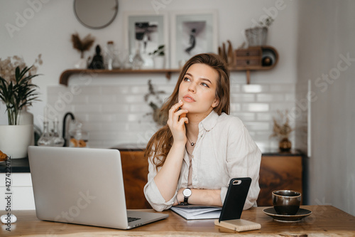 Emotional young woman using her laptop at home