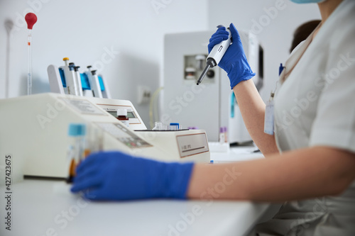 Female in latex gloves carrying out a coagulation test