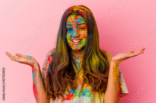 Young Indian woman celebrating holy festival isolated on white background showing a welcome expression.
