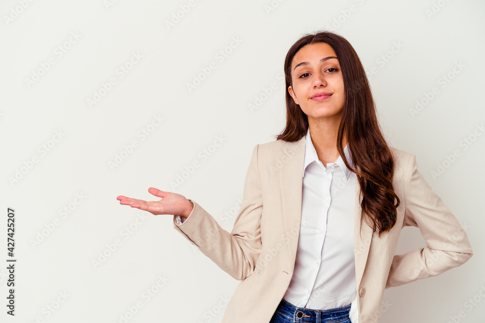 Young Indian business woman isolated on white background showing a copy space on a palm and holding another hand on waist. Young Indian business woman isolated on white background showing a copy space on a palm and holding another hand on waist.