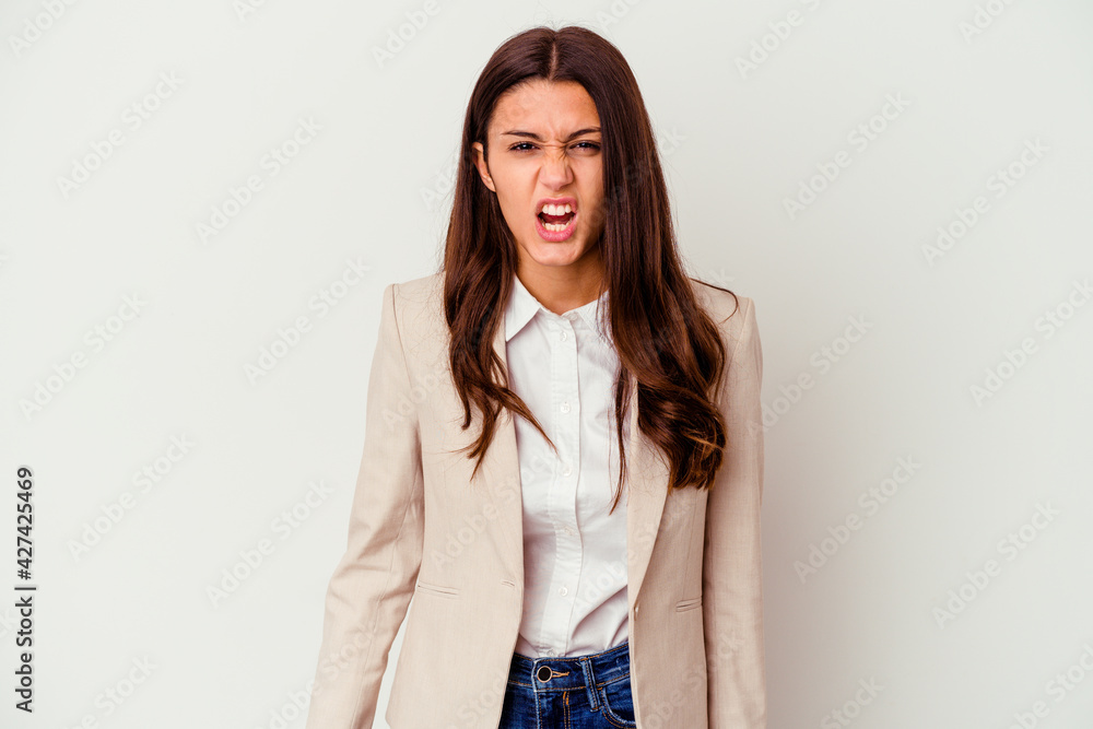 Young Indian business woman isolated on white background screaming very angry and aggressive.