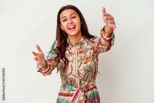 Young Indian woman isolated on white background feels confident giving a hug to the camera.