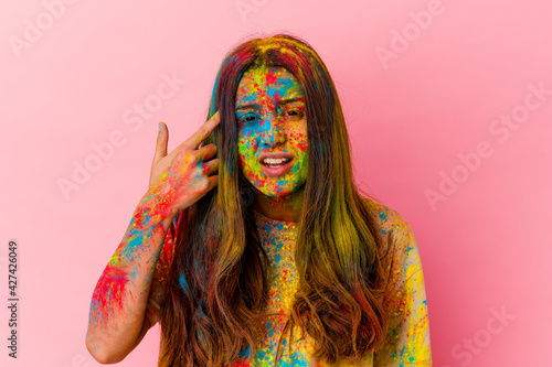 Young Indian woman celebrating holy festival isolated on white background showing a disappointment gesture with forefinger.