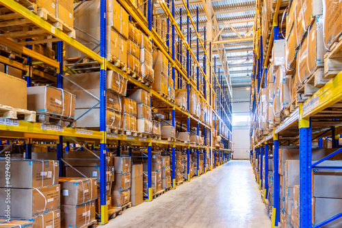 Interior of a modern warehouse storage with rows and goods boxes on high shelves