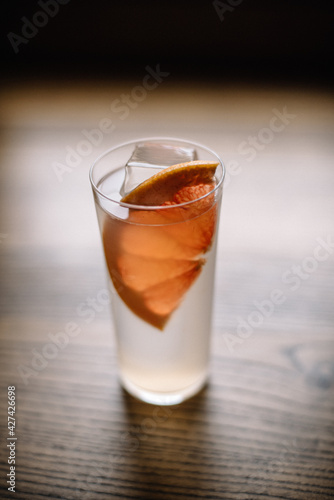 Paloma cocktail. Tequila based cocktail in a highball glass decorated with fresh grapefruit slice.	