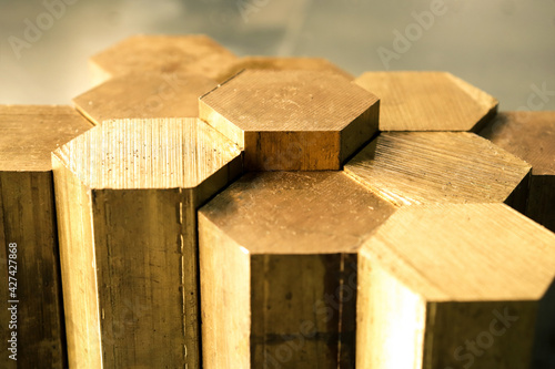 Hexagon made of brass sawn into blanks for further processing on a metalworking machine. Metal cutting in production.  photo