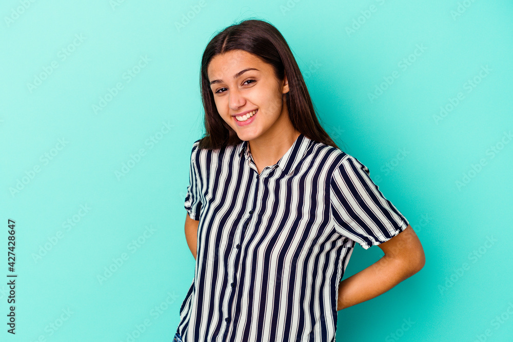 Young Indian woman isolated on blue background happy, smiling and cheerful. Young Indian woman isolated on blue background happy, smiling and cheerful.
