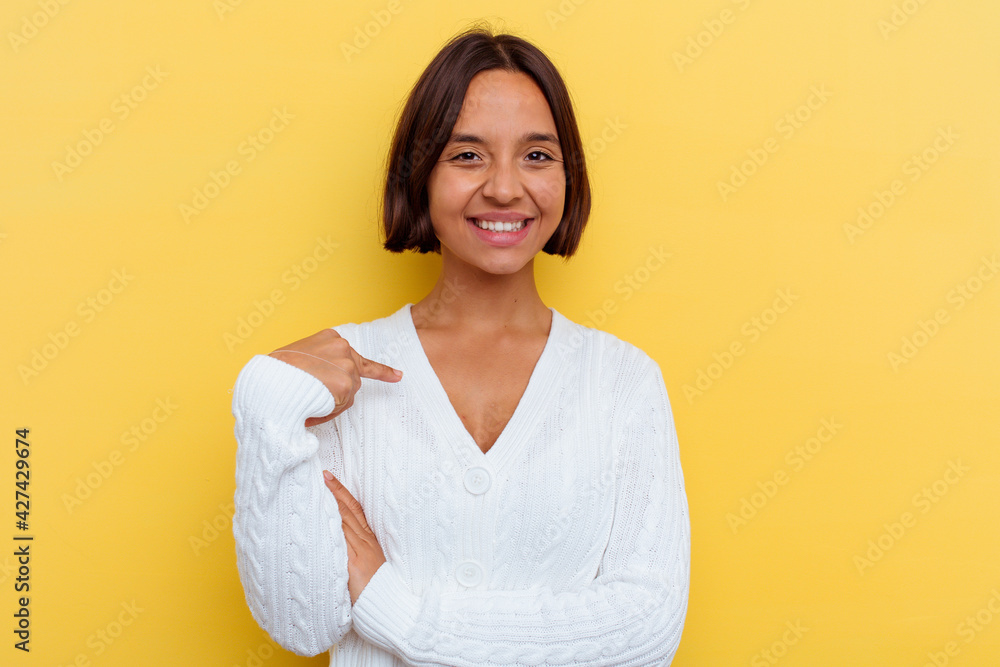 Young mixed race woman isolated on yellow background person pointing by hand to a shirt copy space, proud and confident Young mixed race woman isolated on yellow background person pointing by hand to a shirt copy space, proud and confident