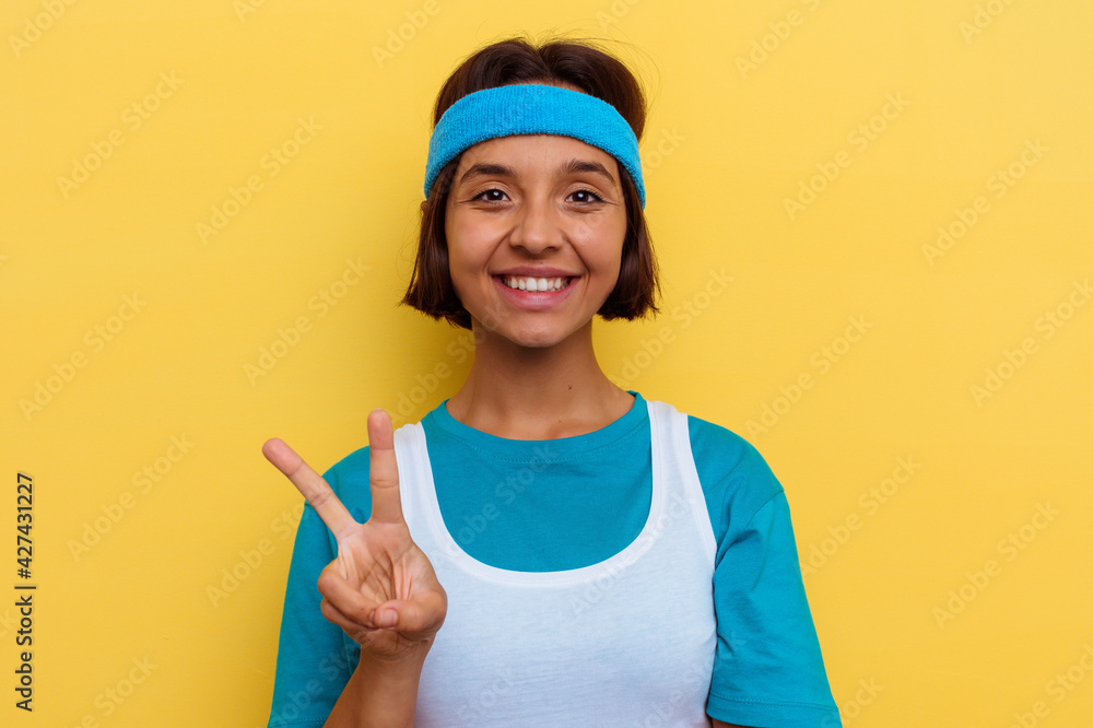 Young sport mixed race woman isolated drinking an energy drink on yellow background Young sport mixed race woman isolated drinking an energy drink on yellow background