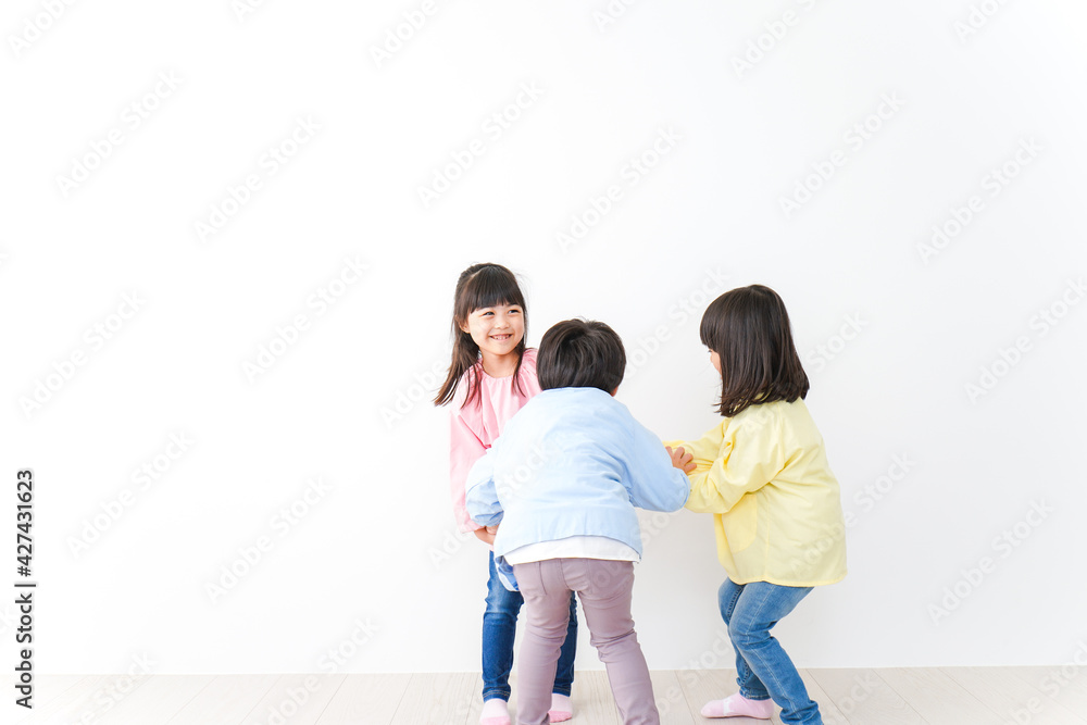 壁に並ぶ3人の幼稚園児 壁に並ぶ3人の幼稚園児