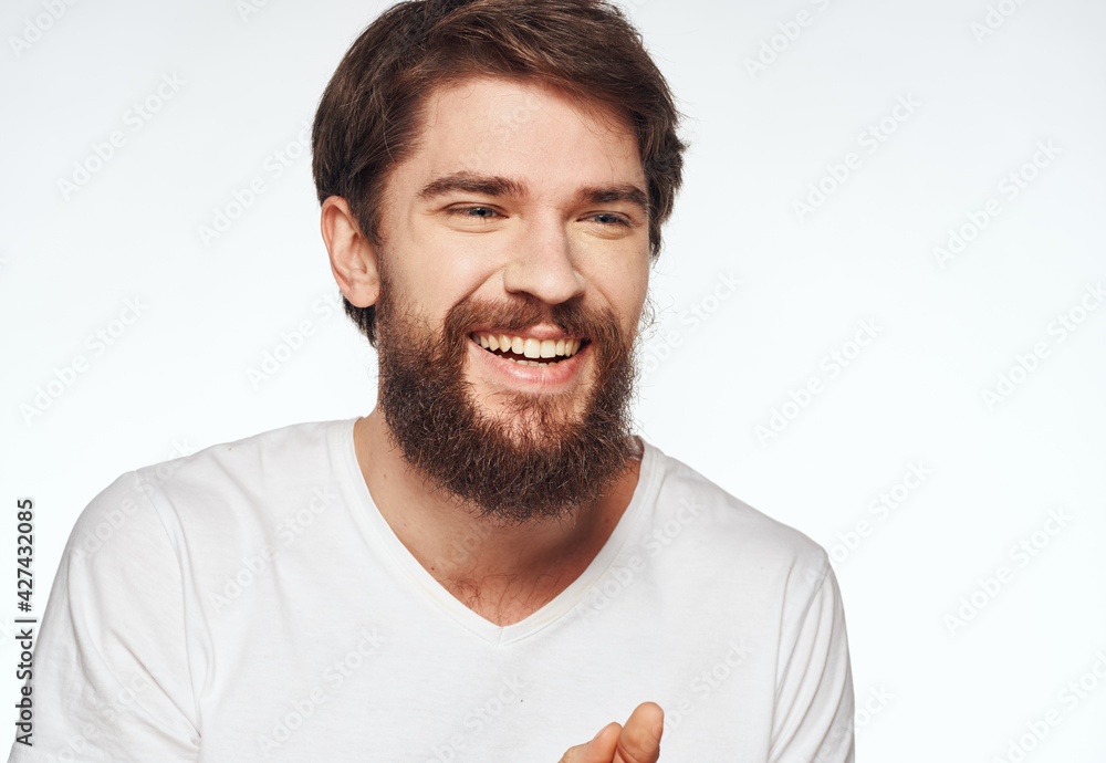 A man in a white T-shirt on a light background beautiful face Happy look A man in a white T-shirt on a light background beautiful face Happy look
