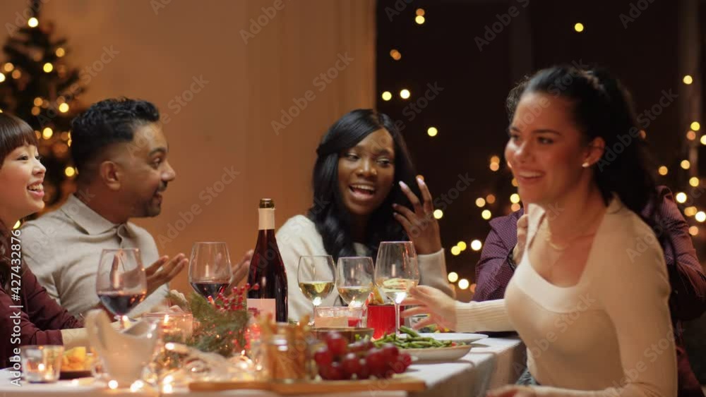 winter holidays, celebration and people concept - happy friends having christmas dinner at home and taking selfie with spartphone winter holidays, celebration and people concept - happy friends having christmas dinner at home and taking selfie with spartphone
