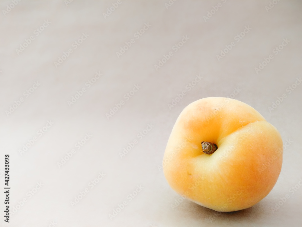 Close up apricot on beige background with copy space. Texture of yellow ripe apricot fruit. Summer berries and fruits. Seasonal harvest. Close up apricot on beige background with copy space. Texture of yellow ripe apricot fruit. Summer berries and fruits. Seasonal harvest.