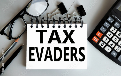 tax evaders. text on white paper on gray background