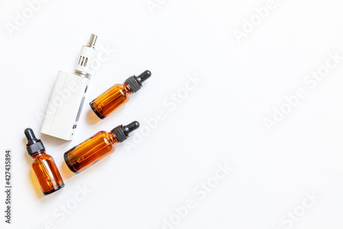 Vaping device e-cigarette electronic cigarette and liquid bottles isolated on white background. Vape device for alternative smoking. Vaping shop concept. Gadget for vaper. Vaping accessories.