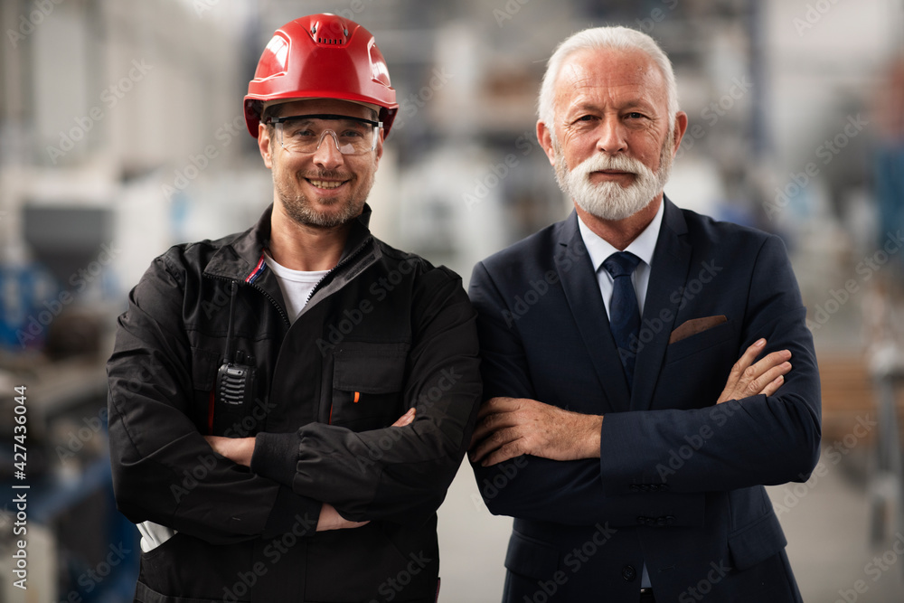 Architect and worker working on project. Colleagues working in factory. Architect and worker working on project. Colleagues working in factory.