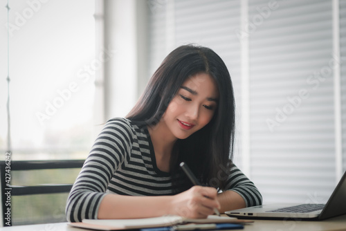 Businesswoman taking idea business in notebook at office. © ic36006