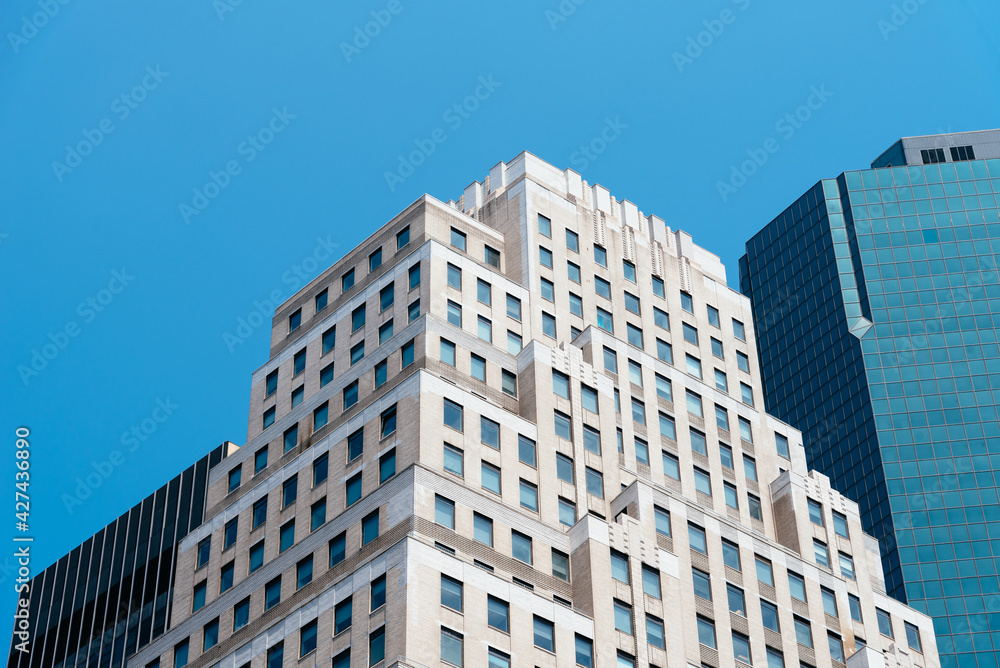 Low Angle View of Office Buildings in Downtown District of New York. Skyscrapers with Technology and Financial companies. Modern workspaces and rental concepts. Low Angle View of Office Buildings in Downtown District of New York. Skyscrapers with Technology and Financial companies. Modern workspaces and rental concepts.