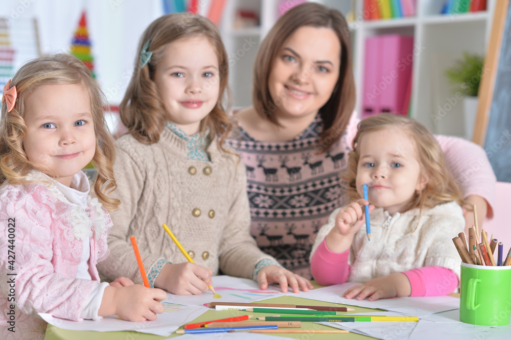 Mother and her three daughters drawing together Mother and her three daughters drawing together