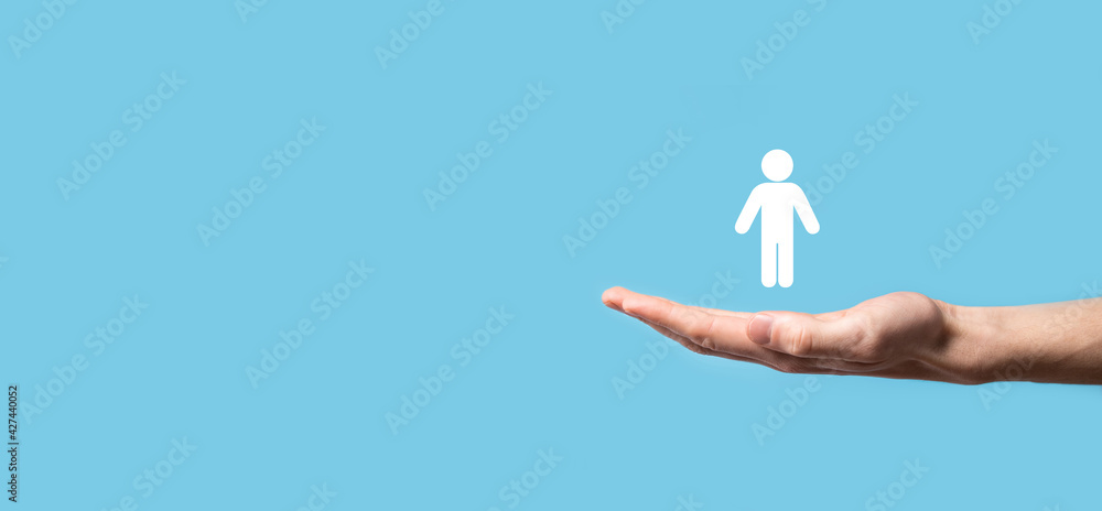 Obraz premium Male hand holding human icon on blue background. Human Resources HR management Recruitment Employment Headhunting Concept.Select team leader concept. Male hand click on man icon.Banner ,copy spase.