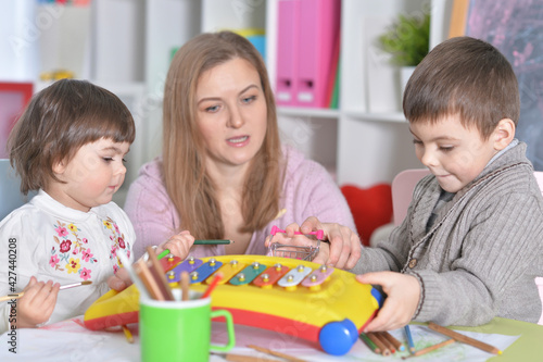 Mother with children playing together at home