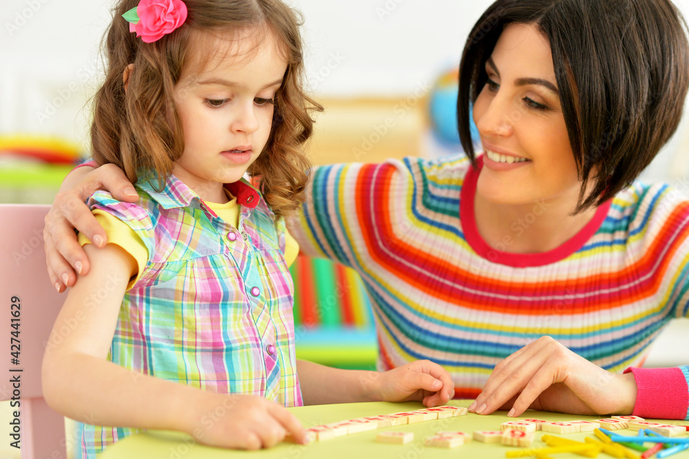 Fototapeta premium Cute little girl with her mother studying